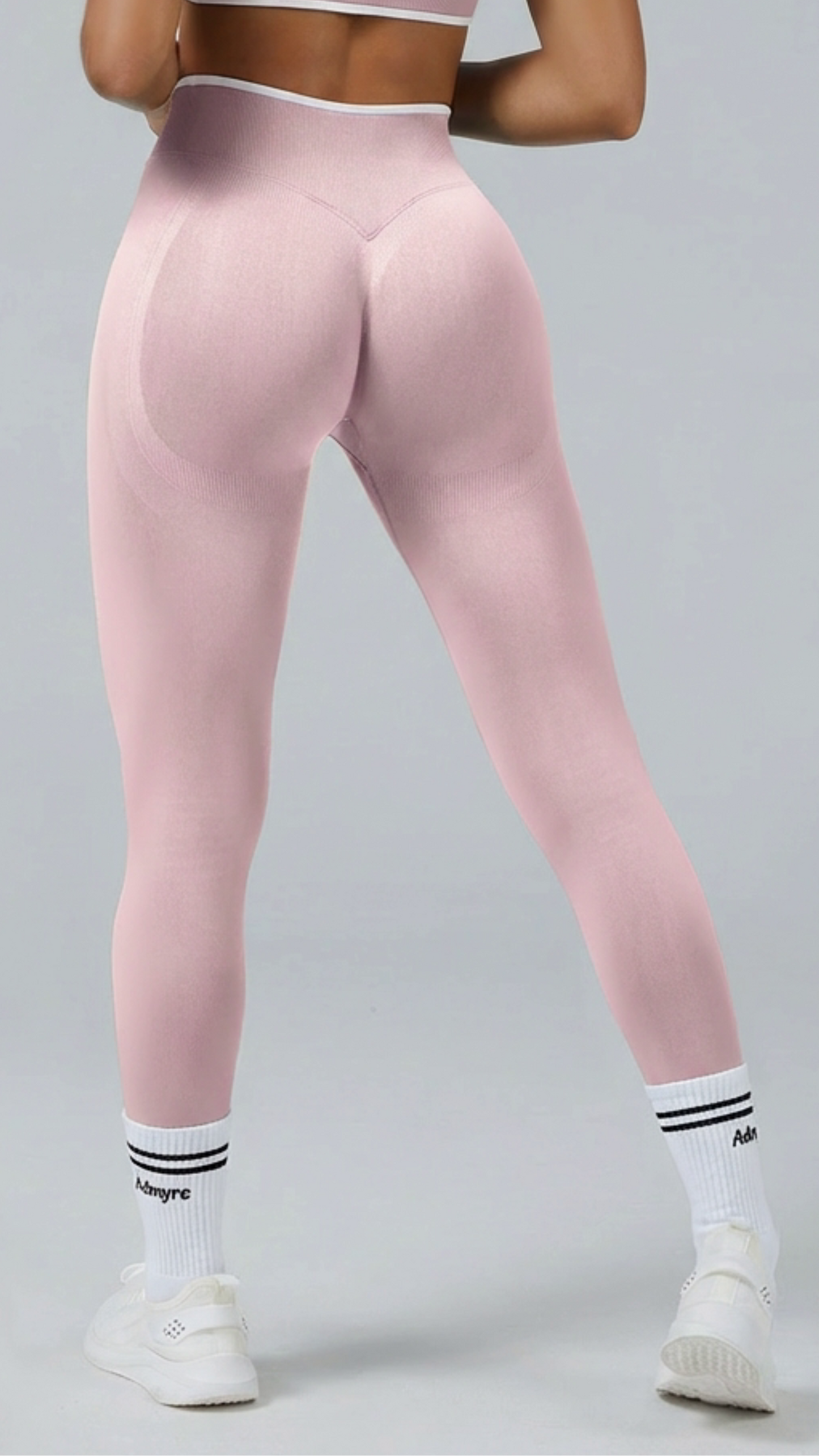 Legging bicolor de Admyre con líneas blancas, diseño seamless y efecto que estiliza la silueta