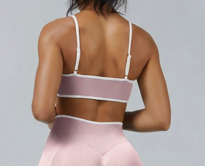 Top deportivo bicolor de Admyre con líneas blancas, diseño seamless y ajuste de soporte