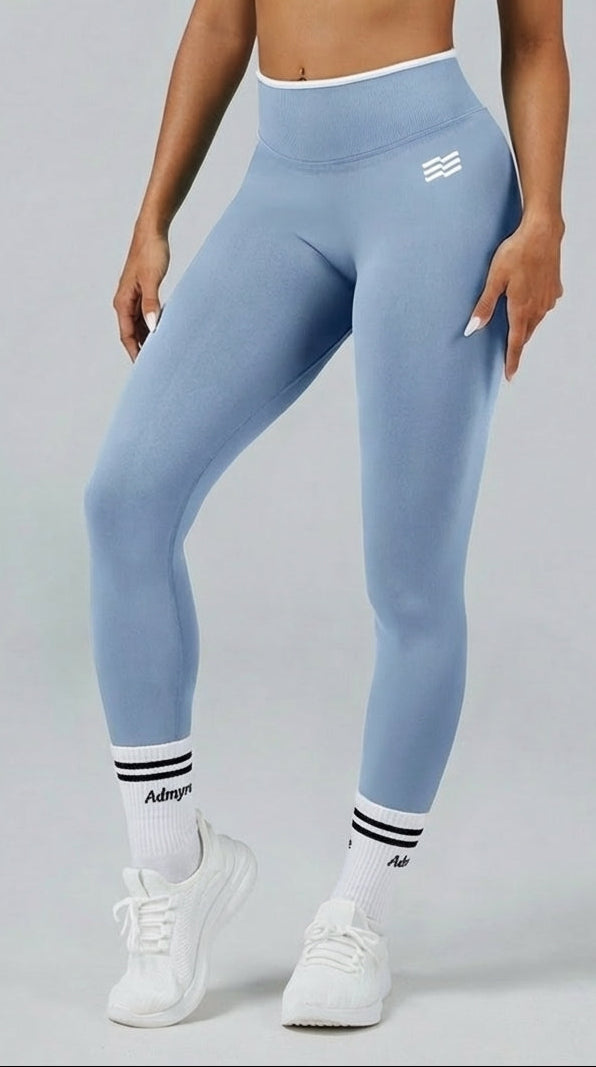 Legging bicolor de Admyre con líneas blancas, diseño seamless y efecto que estiliza la silueta