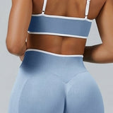 Top deportivo bicolor de Admyre con líneas blancas, diseño seamless y ajuste de soporte